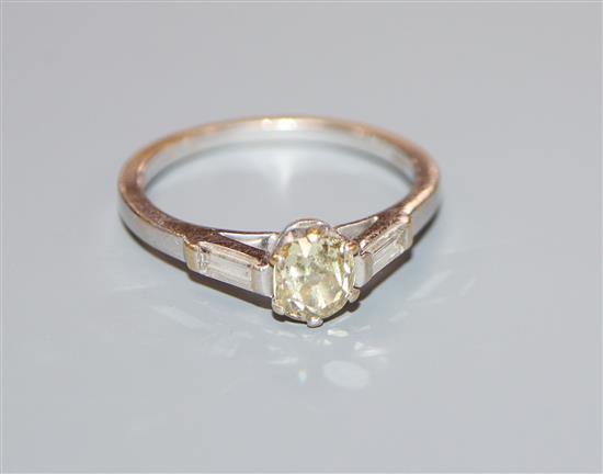 A modern 18ct white gold and fancy yellow single stone diamond ring, with baguette cut diamond set shoulders, size Q.